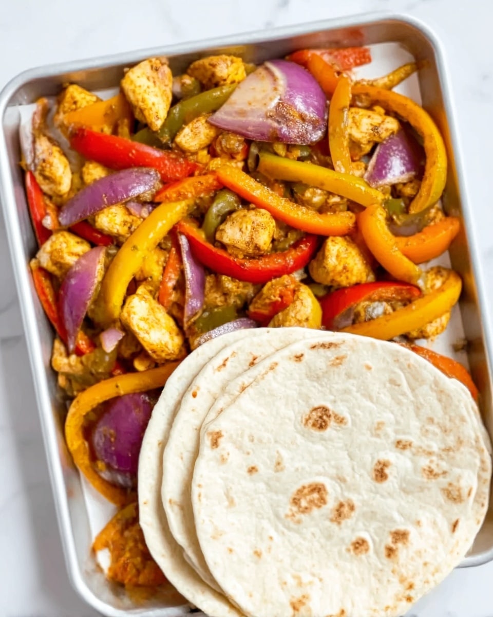 A close-up view of a tray filled with cooked pieces of grilled chicken mixed with sautéed sliced bell peppers in red, yellow, and orange colors along with thin strips of cooked red onions, all showing a slightly charred texture. On the bottom right corner of the tray, there are three soft, round white tortillas stacked slightly overlapping each other, showing light brown spots from cooking. The entire scene rests on a white marbled surface. Photo taken with an iphone --ar 4:5 --v 7