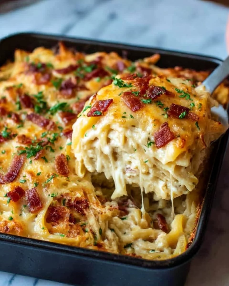 The image shows a close-up of a baked pasta casserole in a black square baking dish on a white marbled surface. The casserole has multiple layers: at the bottom is a creamy white pasta mix with visible noodles, topped with a golden-brown melted cheese layer scattered with small crispy bacon pieces and green herbs, adding texture and color contrast. A woman’s hand is holding a spatula scooping some pasta from the corner, revealing the soft, creamy inside. The melted cheese is shiny and slightly browned on top. Photo taken with an iphone --ar 4:5 --v 7