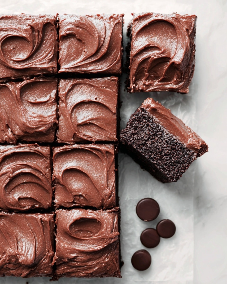 A grid of nine square, rich chocolate brownies sits on a white marbled surface, each piece topped with a thick, smooth, and creamy layer of chocolate frosting that has soft swirls and a glossy texture. One brownie is slightly pulled away from the corner, showing the dense, moist inside beneath the frosting. Near the bottom edge of the image, three round chocolate pieces lie on the white marbled background, adding to the chocolate theme. The deep brown colors of the brownies and frosting contrast well with the bright, clean white marbled surface. photo taken with an iphone --ar 4:5 --v 7