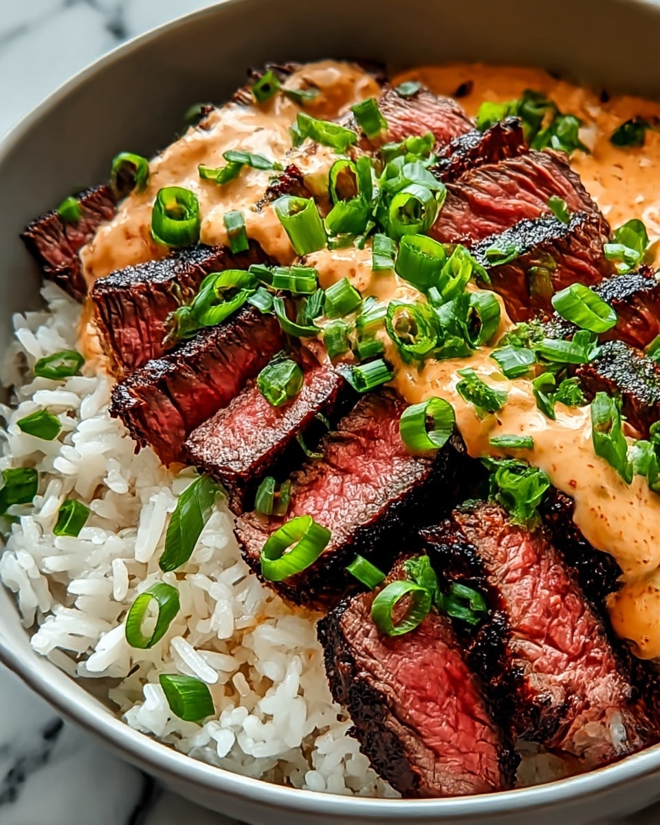 A close-up view of a bowl with three main layers: the bottom is soft, white rice with a slightly shiny texture, above it are thick slices of grilled steak with a dark, charred crust and a pink center, arranged side by side, and the top layer is a creamy, light orange sauce drizzled over the steak, sprinkled with fresh, chopped bright green scallions. The bowl is white and the background has a white marbled texture. photo taken with an iphone --ar 4:5 --v 7